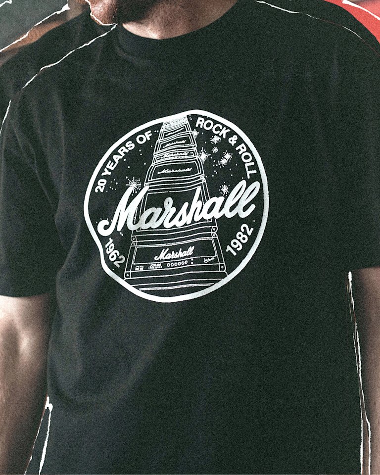 A person is wearing a black Marshall t-shirt