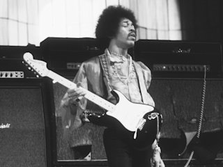 Jimi Hendrix holding his guitar in a Black and White photo