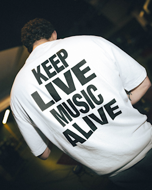 A person wearing the KLMA Tshirt in white