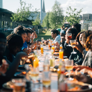 A group of people sharing an outdoor lunch at a long table
