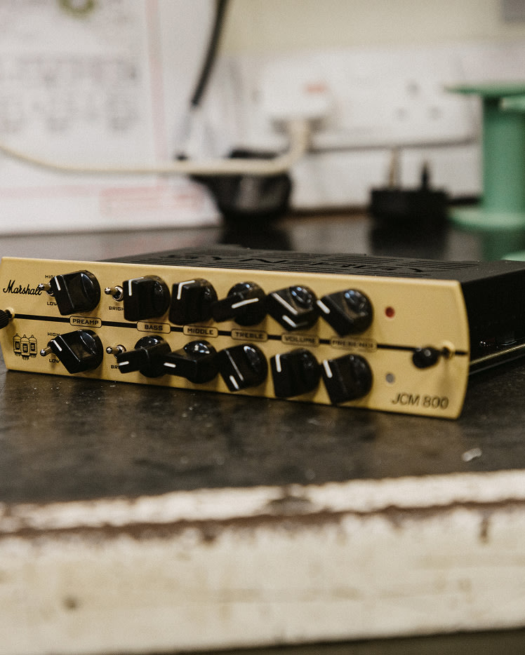 Marshall JCM800 Synergy Preamp Module sits on a workbench, showing various control knobs and input jacks.