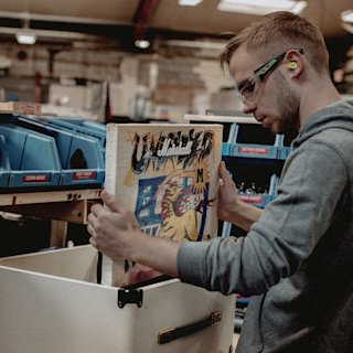 A man installing a printed canvas into a Studio 900 Combo Lunar New Year Edition 2026 amplifier at the Marshall factory.
