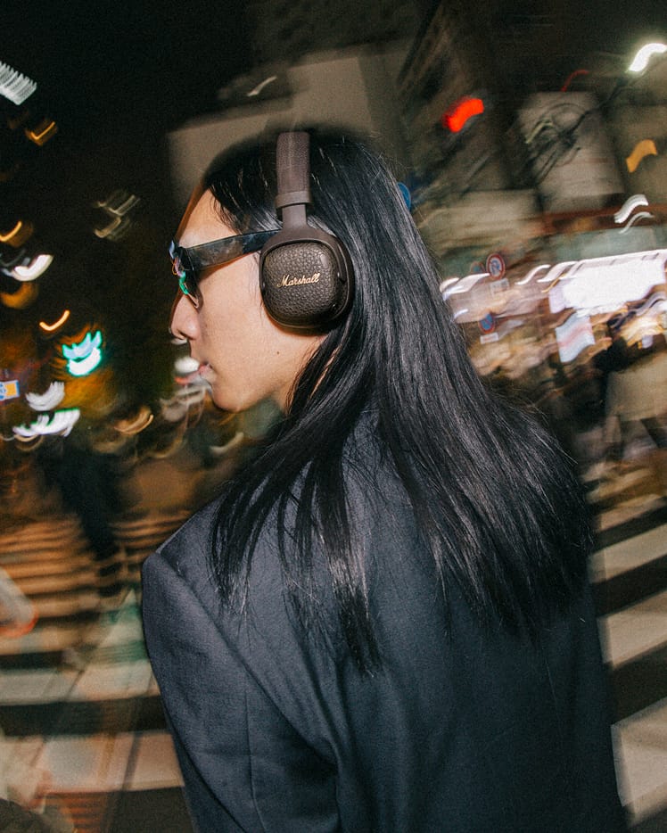 A person walking through a lively city wearing the Milton A.N.C. in Brown
