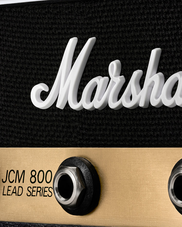 Close-up of a Jack Rack JCM800: Reissue showing the white logo, black textured surface, gold panel, and input jack.