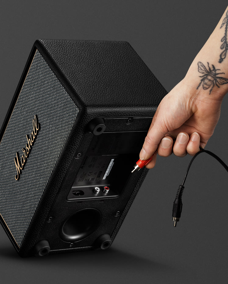 Connecting an RCA cable into the back of Marshall Acton IV Black speaker.