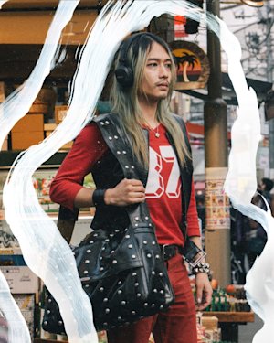 A person is standing on a busy road wearing Milton A.N.C. headphones