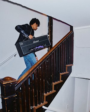 Zach Person going up the stairs with an amp