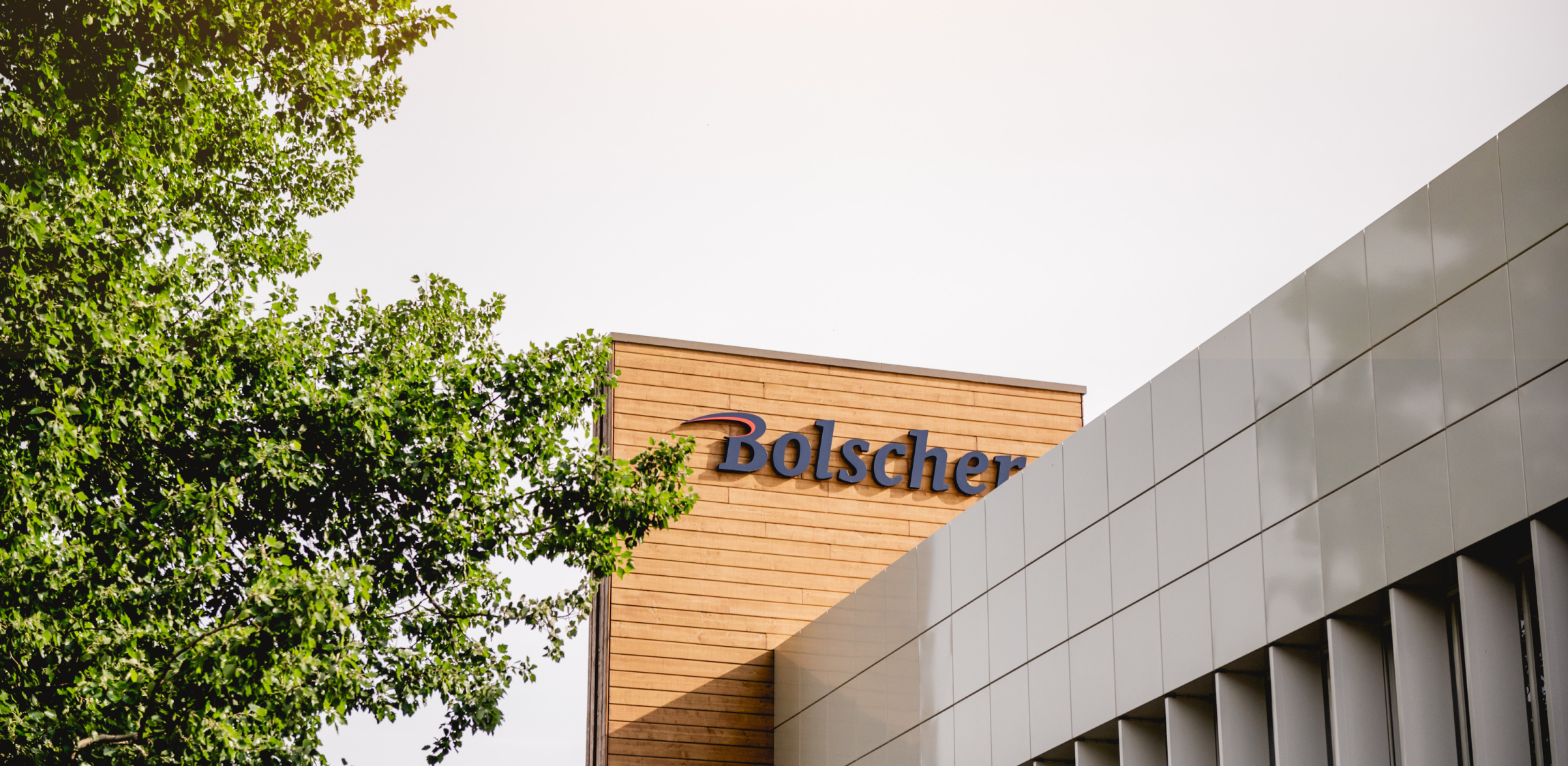 Een blauw Bolscher busje komt aangereden bij een Bolscher gebouw.