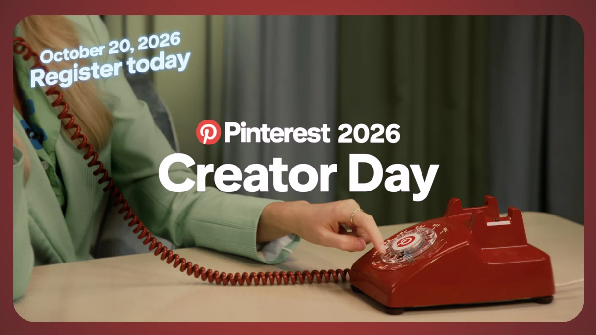 A woman's torso with head out of frame. She is sitting at a table, wearing sea foam suit and dialing a red rotary phone with the Pinterest "P" icon in the center.