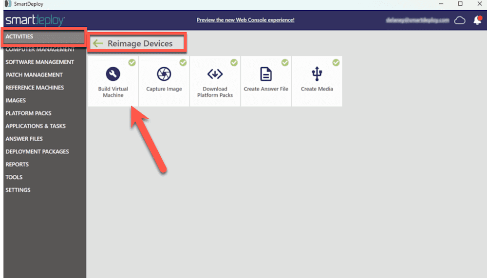Screenshot of the SmartDeploy software interface highlighting the "Reimage Devices" section under the "Activities" menu. A red arrow points to the "Build Virtual Machine" option, which is part of a horizontal row of tasks including "Capture Image," "Download Platform Packs," "Create Answer File," and "Create Media." The interface has a dark sidebar with menu options and a header with a preview link to the Web Console experience.