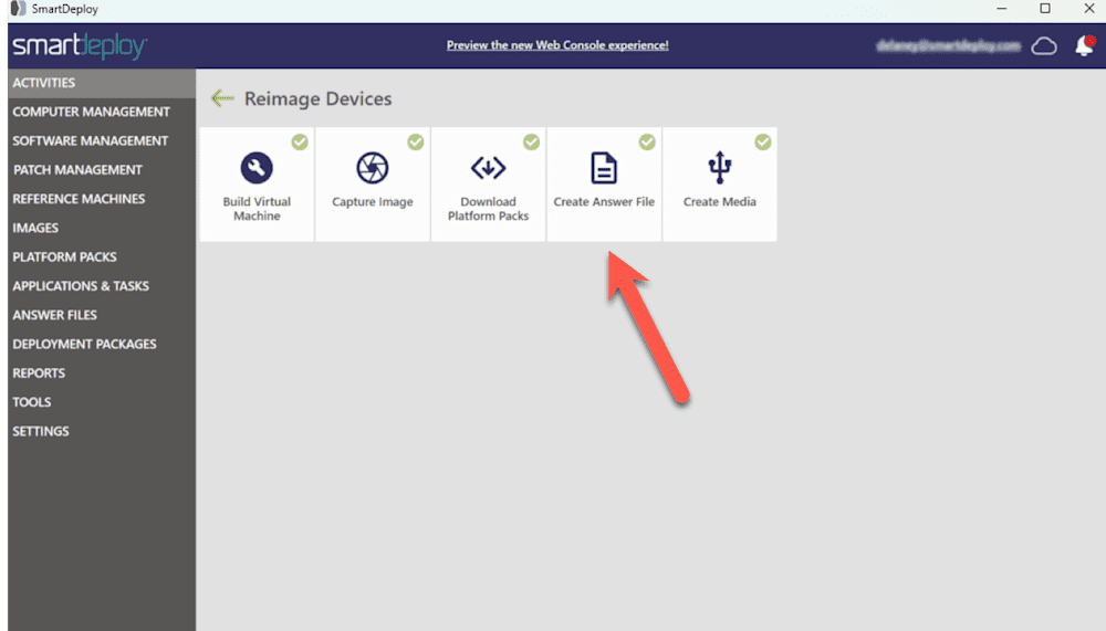 Screenshot of the SmartDeploy interface in the "Reimage Devices" section. A red arrow highlights the "Create Answer File" tile, which is positioned between the "Download Platform Packs" and "Create Media" options. Other visible task tiles include "Build Virtual Machine" and "Capture Image." The left navigation panel includes menu categories such as Activities, Computer Management, Software Management, Patch Management, and others. A header bar at the top contains a link to preview the new Web Console experience and shows a logged-in user profile on the right.