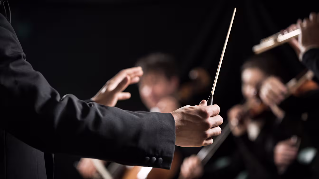 Klassische Musik – eine wundervolle Welt erleben Dirigent mit Taktstock leitet ein Orchester während einer klassischen Musikaufführung