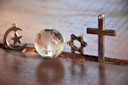 Symbole der drei Religionen - Judentum, Christentum und Islam mit einer Kristallkugel