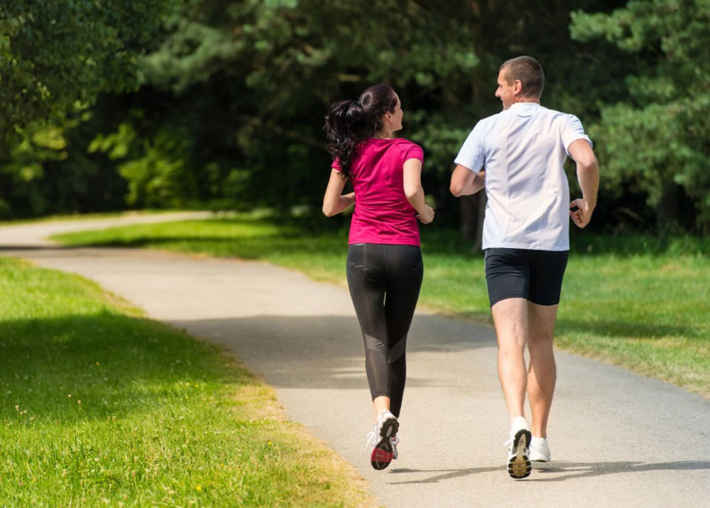 una mujer y un hombre corriendo por el parque