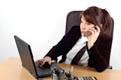 woman using a laptop while talking on phone