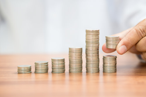 Stacks of coins, a hand removing half of a stack.