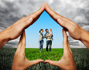 hands showing house with family