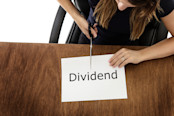 woman cutting paper with dividend written on it
