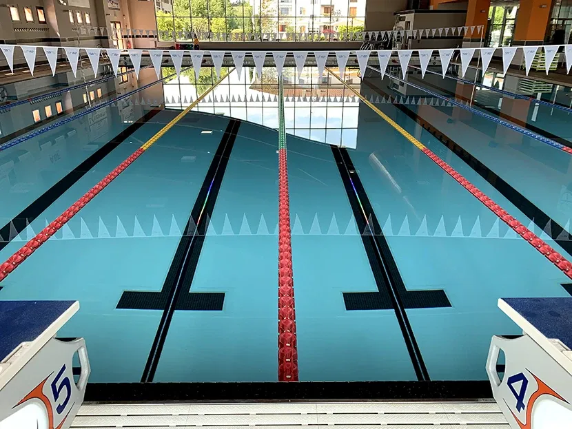 una piscina dove si vedono sul fondo delle strisce led luminose che guidano i nuotatori