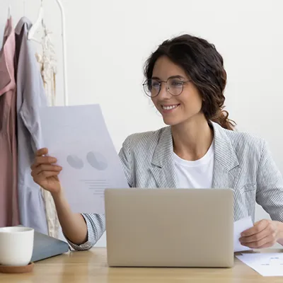 Una donna sorridente davanti alla scrivania nel proprio ufficio.