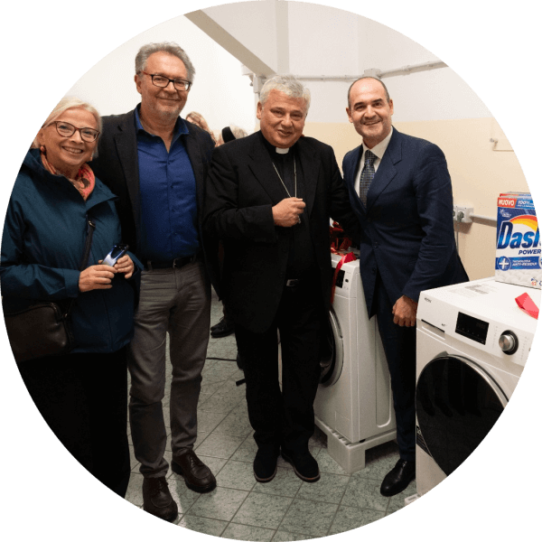 Daniela Sironi, Saverio Serrano', il Cardinale Konrad Krajewski e Riccardo Calvi posano affianco a una delle lavatrici donate da Haier Europe con sopra prodotti Dash e Lenor donati da P&G