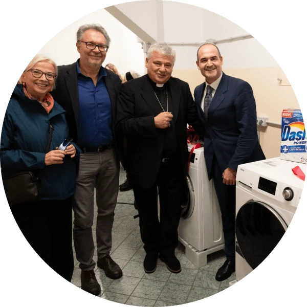Daniela Sironi, Saverio Serrano', il Cardinale Konrad Krajewski e Riccardo Calvi posano affianco a una delle lavatrici donate da Haier Europe con sopra prodotti Dash e Lenor donati da P&G