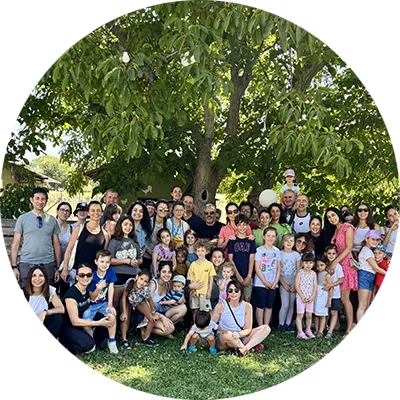 un ampio gruppo di dipendenti di P&G Italia composto da 47 bambini e dai loro genitori in posa sotto a un castagno secolare presso la Cooperativa Capodarco di Grottaferrata (RM).
