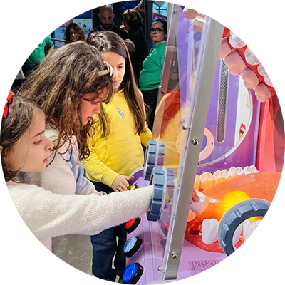 Due bambine di 6 anni giocano con l’installazione che rappresenta una bocca gigante.