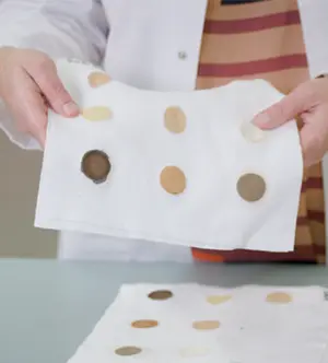 una ricercatrice mostra una salvietta con delle macchie di sporco che viene utilizzata per testare l'efficacia del prodotto