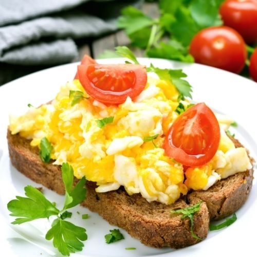 Jajecznica dobrze smakuje podana na chlebie z pomidorami