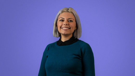 Elba Ada's new Spanish language copywriter, Elba, in front of a purple background.