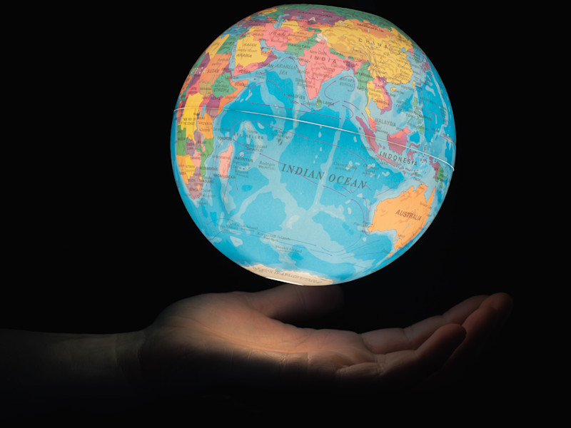An image of a hand holding an illuminated globe