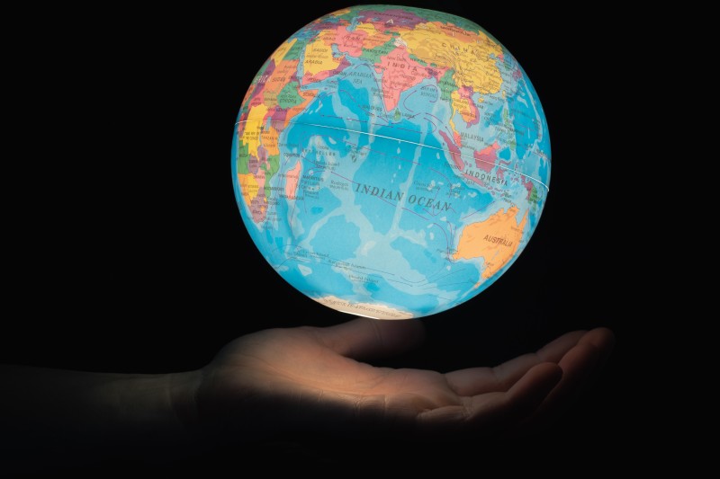 An image of a hand holding an illuminated globe