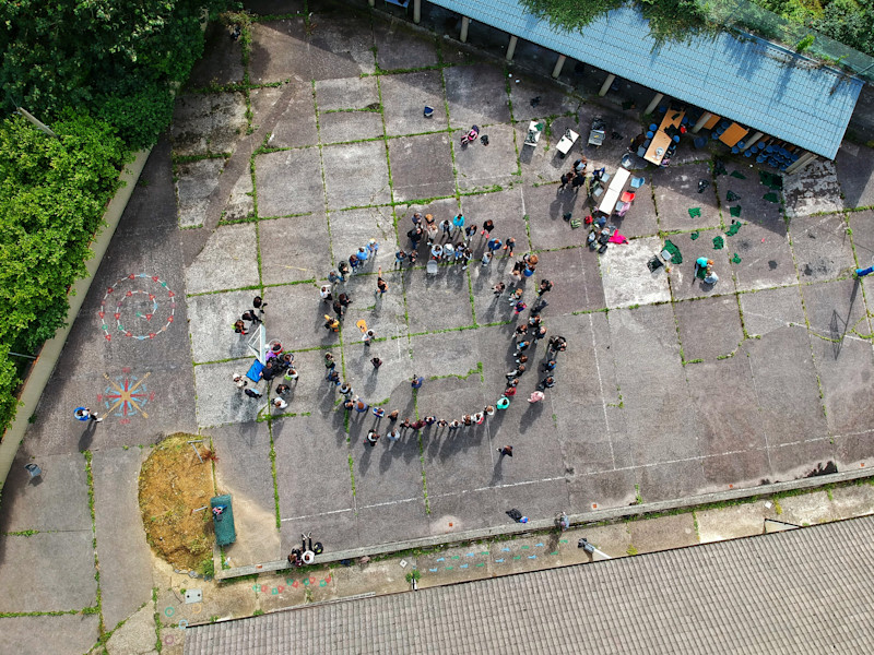 Image of aerial view of people standing in a circle