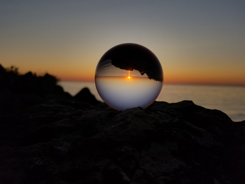 Image looking through a transparent sphere to a sunset