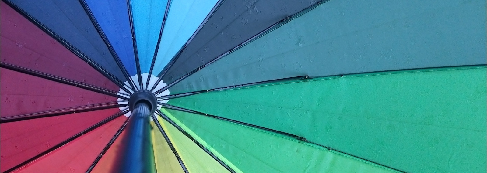 Image looking up to the hub of a colourful umbrella