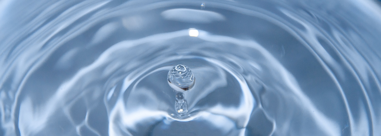 Image of spherical water droplet falling into water