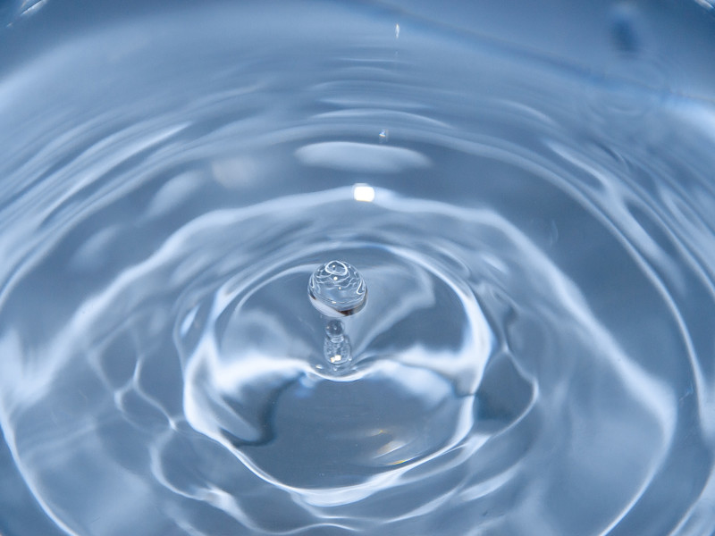 Image of spherical water droplet falling into water