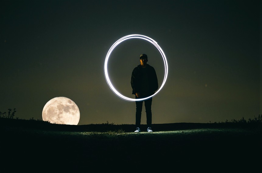 man standing behind an illuminated circle