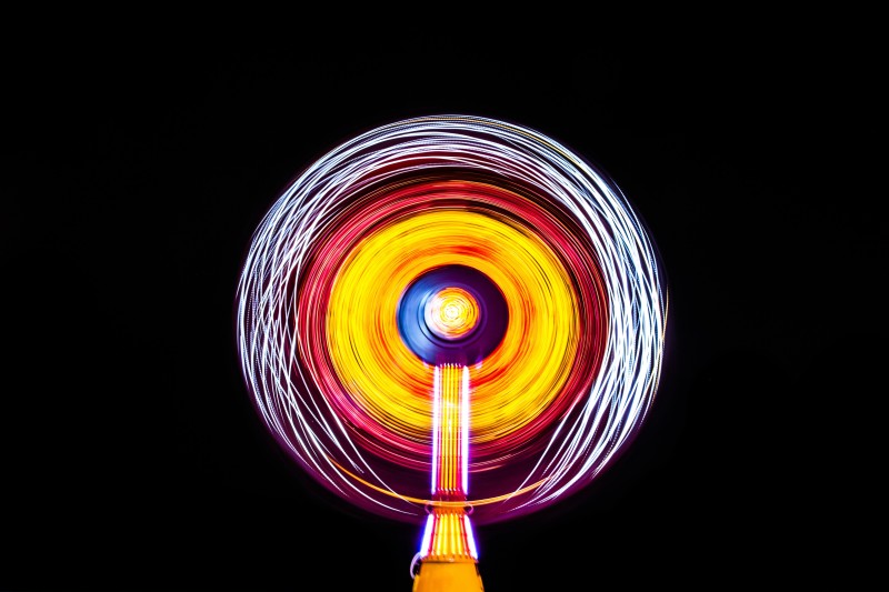 Image of circular light image emitted by a Ferris wheel in the night sky