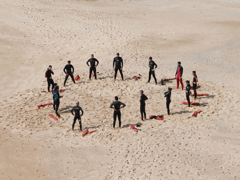 Image of a circle of people standing on a beach