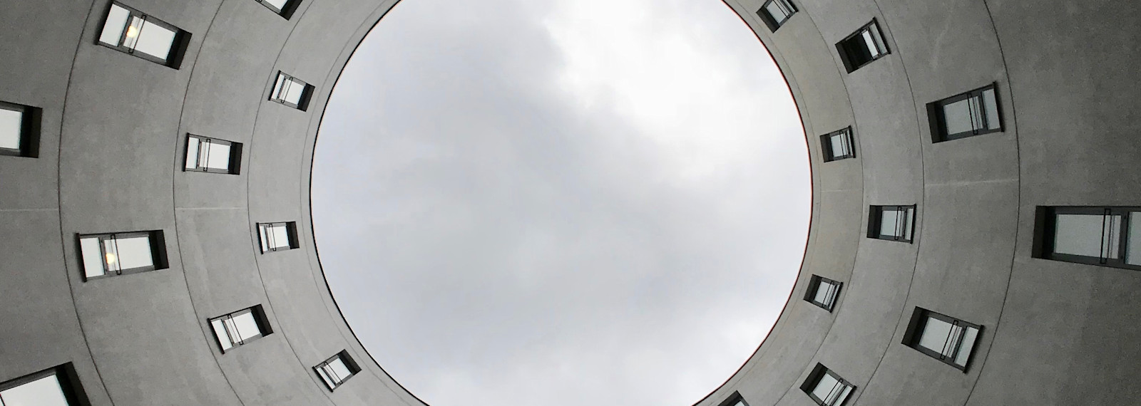 Image looking up at the sky through a circular building