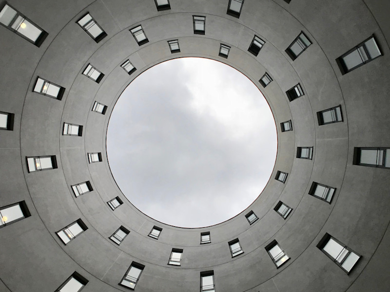 Image looking up at the sky through a circular building