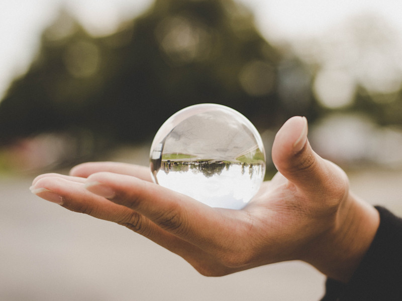 Hand holding a transparent spherical orb