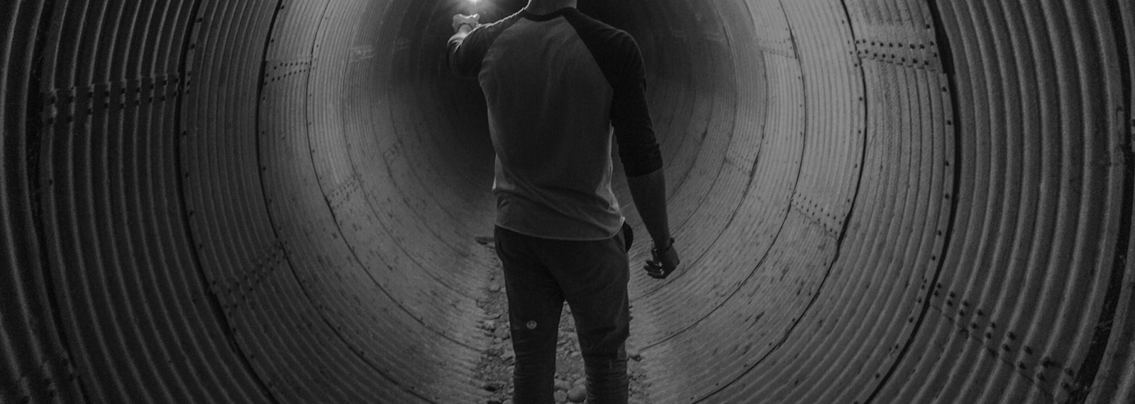 Image of a man walking through a circular tunnel