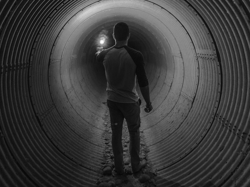 Image of a man walking through a circular tunnel