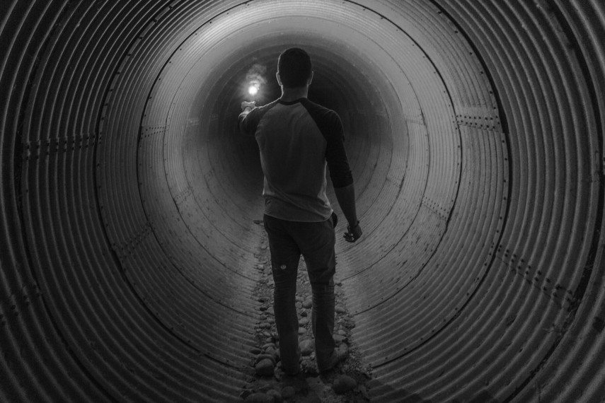 Image of a man walking through a circular tunnel