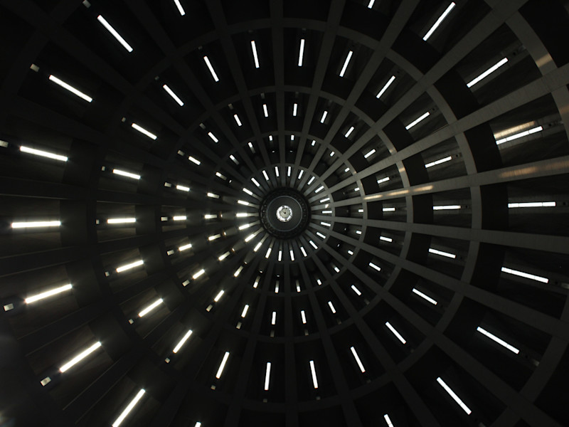 Image looking up into the top of a circular building with narrow windows