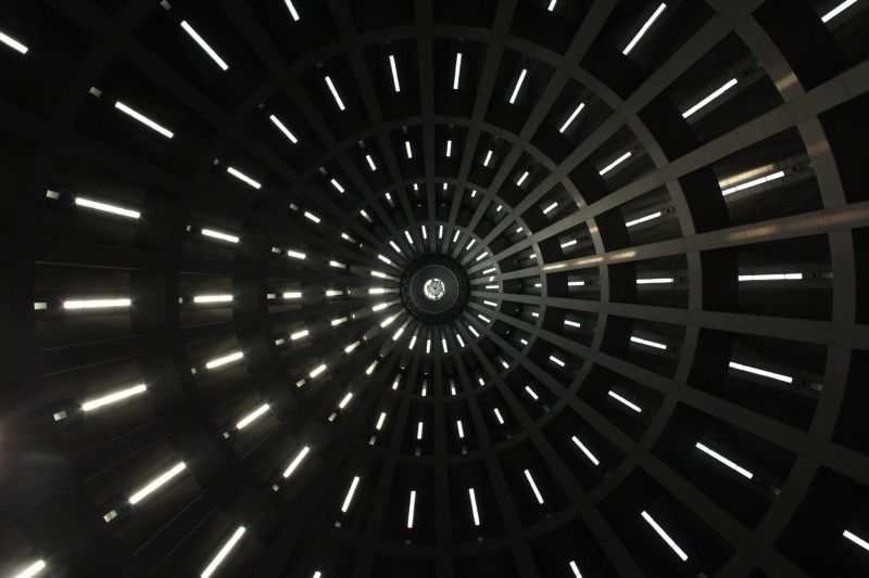 Image looking up into the top of a circular building with narrow windows