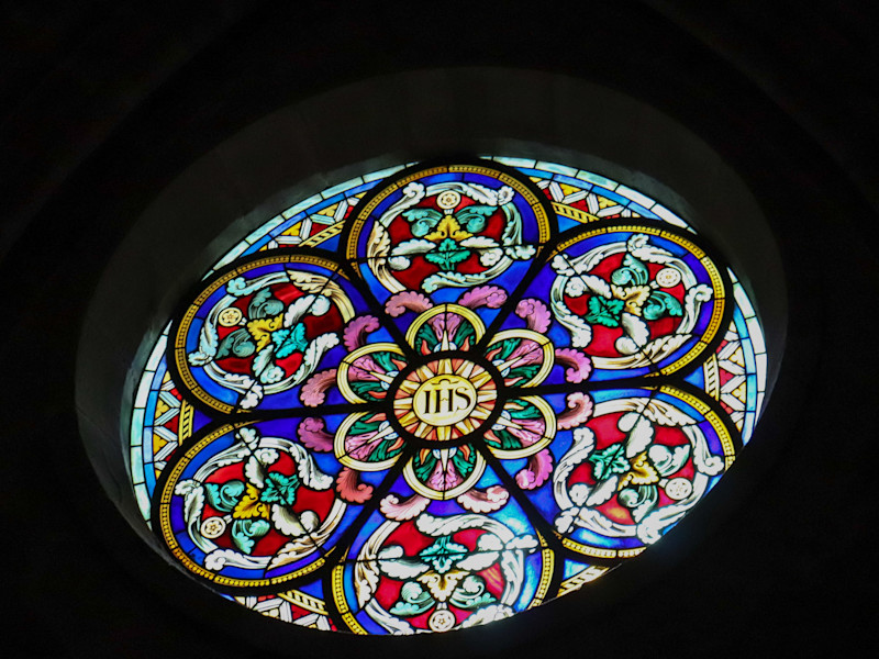 Image looking up at a circular stained glass window